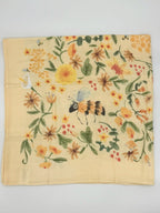 Baby Bites Honey Farm bamboo muslin swaddle blanket with bees, flowers and honeycomb illustrations quarter2